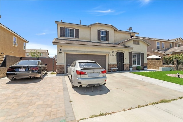 3042 San Luis Dr, Lancaster, CA 93535 - view of front of house featuring driveway, stucco siding, an attached garage, a gate, and brick siding