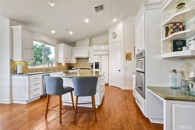 1177 Estee Ct, Fallbrook, CA 92028 - kitchen featuring double oven, white cabinets, backsplash, light wood-style floors, and recessed lighting