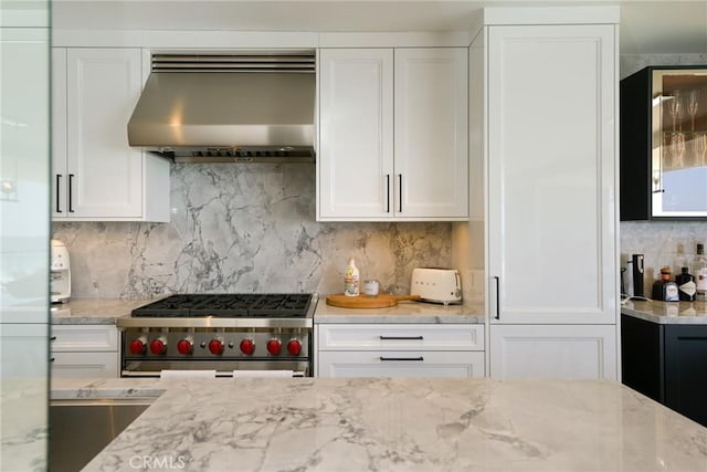 1585 S Coast Unit 2, Laguna Beach, CA 92651 - kitchen with range hood, high end range, decorative backsplash, white cabinets, and light stone countertops