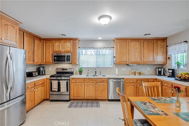 8960 Telfair Ave, Sun Valley, CA 91352 - kitchen with appliances with stainless steel finishes, decorative backsplash, light countertops, and light tile patterned flooring
