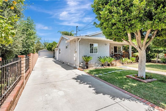 8960 Telfair Ave, Sun Valley, CA 91352 - view of front of house featuring stucco siding, driveway, an outdoor structure, and a detached garage
