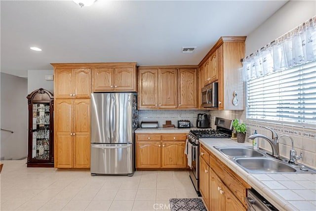 8960 Telfair Ave, Sun Valley, CA 91352 - kitchen featuring appliances with stainless steel finishes, tile countertops, tasteful backsplash, recessed lighting, and light tile patterned flooring