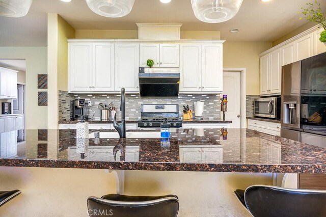 5764 Alcala Way, Riverside, CA 92505 - kitchen featuring appliances with stainless steel finishes, a breakfast bar, decorative backsplash, white cabinetry, and recessed lighting
