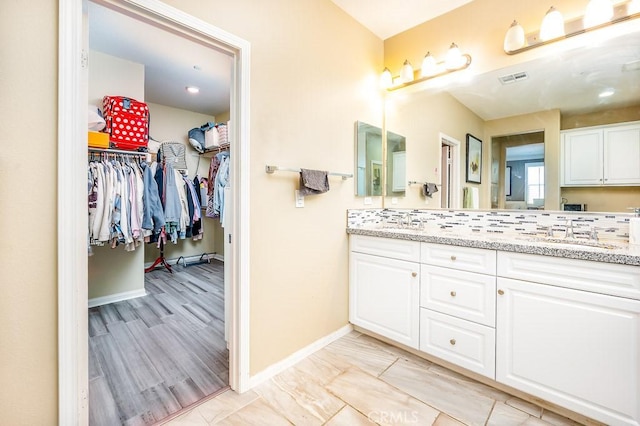 5764 Alcala Way, Riverside, CA 92505 - bathroom with double vanity, baseboards, and a walk in closet