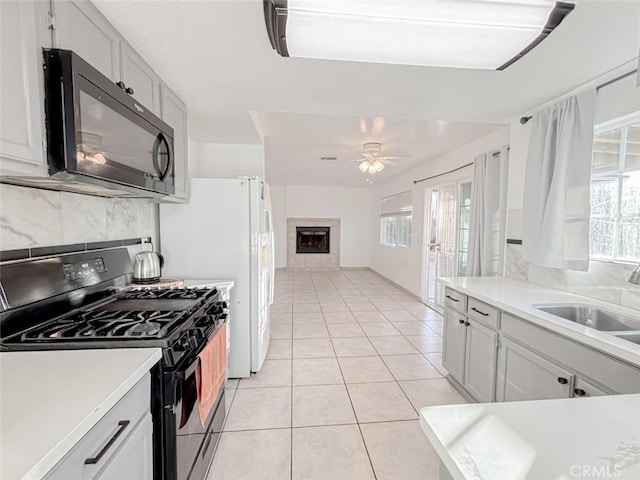 37627 Citrus Dr, Palmdale, CA 93550 - kitchen with stainless steel range with gas cooktop, black microwave, tasteful backsplash, a sink, and light countertops