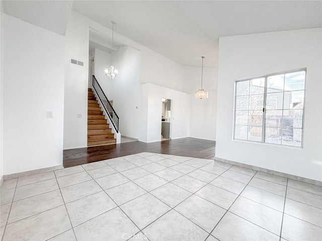 37627 Citrus Dr, Palmdale, CA 93550 - unfurnished living room featuring tile patterned floors, a chandelier, stairway, high vaulted ceiling, and baseboards