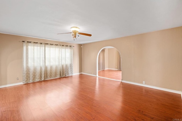 2862 Coronado Ave, San Diego, CA 92154 - empty room featuring ceiling fan, arched walkways, wood finished floors, and baseboards