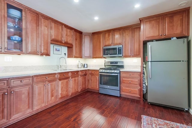1129 La Casa, San Marcos, CA 92078 - kitchen featuring appliances with stainless steel finishes, dark wood-style flooring, brown cabinets, recessed lighting, and glass insert cabinets