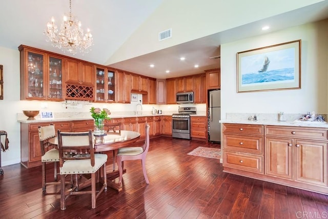 1129 La Casa, San Marcos, CA 92078 - kitchen with stainless steel appliances, brown cabinetry, dark wood finished floors, recessed lighting, and high vaulted ceiling