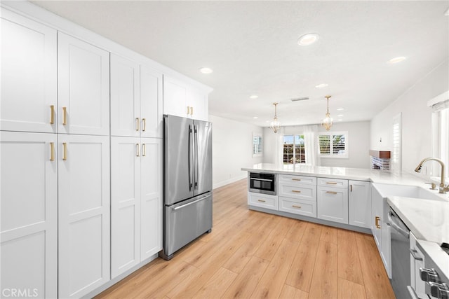 25311 Misty Rdg, Mission Viejo, CA 92692 - kitchen with appliances with stainless steel finishes, a sink, recessed lighting, white cabinets, and light wood-type flooring