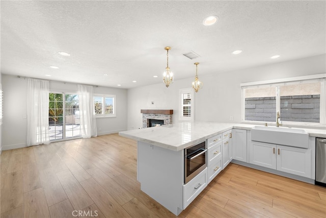 25311 Misty Rdg, Mission Viejo, CA 92692 - kitchen featuring a sink, a peninsula, a brick fireplace, open floor plan, and recessed lighting