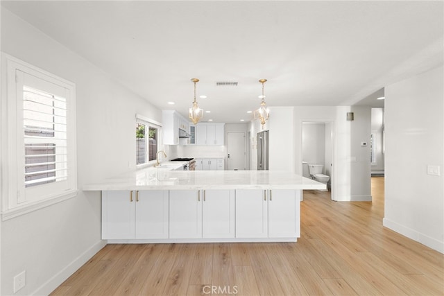 25311 Misty Rdg, Mission Viejo, CA 92692 - kitchen featuring a peninsula, appliances with stainless steel finishes, light countertops, white cabinetry, and baseboards