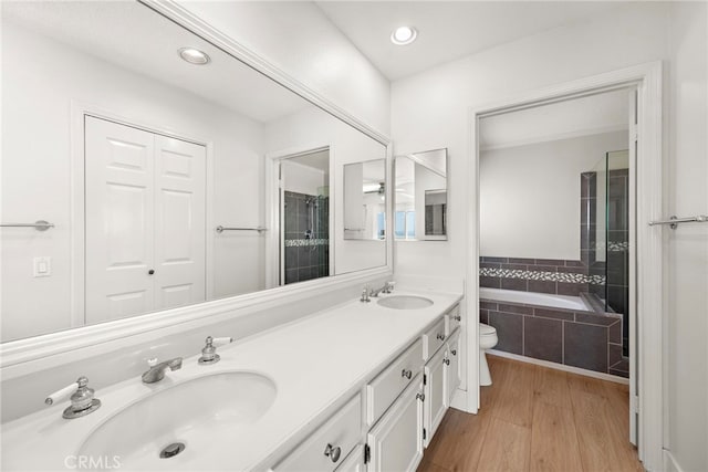 25311 Misty Rdg, Mission Viejo, CA 92692 - bathroom featuring double vanity, toilet, tiled bath, wood finished floors, and recessed lighting