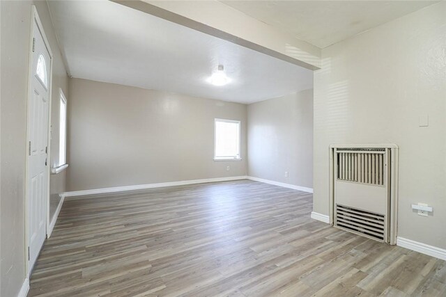 7531 Del Rosa Ave, San Bernardino, CA 92410 - unfurnished living room with heating unit, light wood finished floors, and baseboards