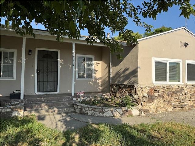 7531 Del Rosa Ave, San Bernardino, CA 92410 - view of exterior entry with a porch, stucco siding, and stone siding