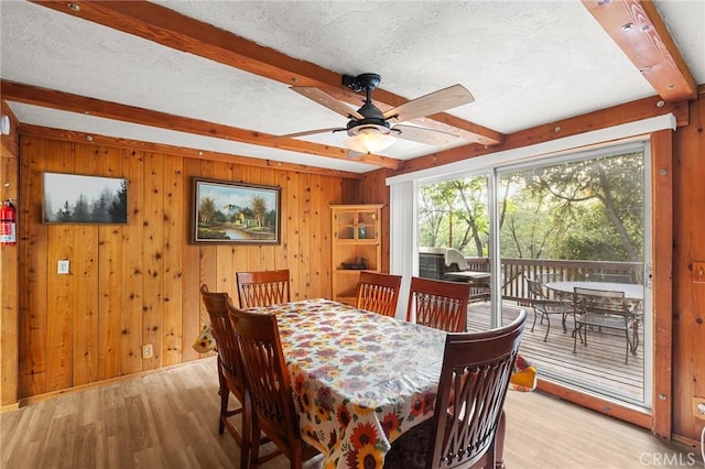 233 Glen Avon Dr, Cedar Glen, CA 92321 - dining room featuring beamed ceiling, light wood finished floors, a textured ceiling, wood walls, and a ceiling fan
