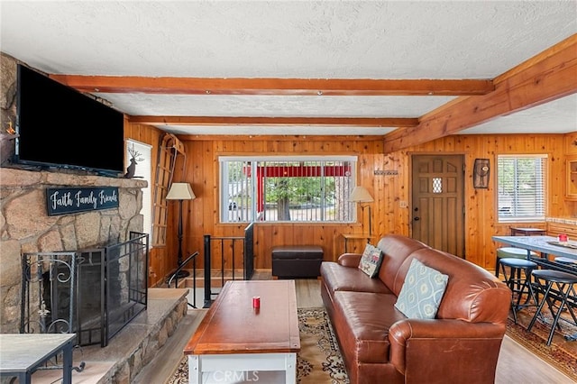 233 Glen Avon Dr, Cedar Glen, CA 92321 - living area with beam ceiling, a textured ceiling, wood finished floors, wood walls, and a fireplace