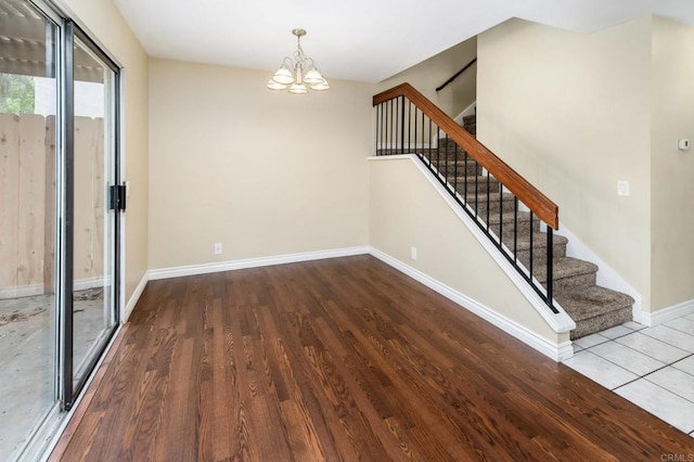 1253 Manzana Way, San Diego, CA 92139 - spare room featuring stairway, a chandelier, wood finished floors, and baseboards