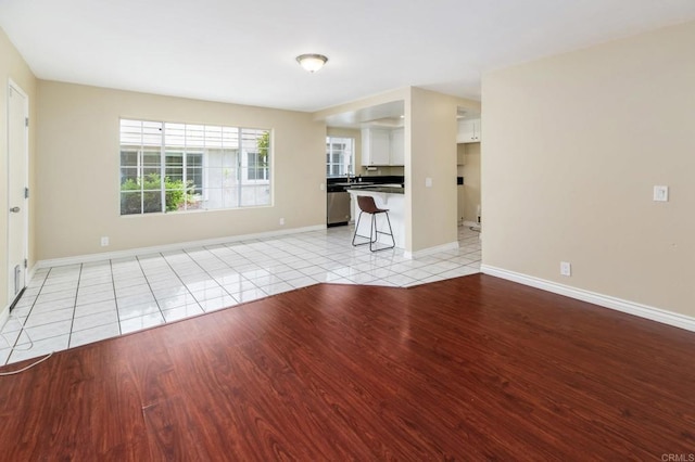 1253 Manzana Way, San Diego, CA 92139 - unfurnished living room featuring light tile patterned floors, baseboards, and a sink