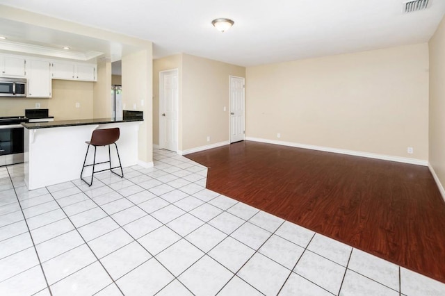 1253 Manzana Way, San Diego, CA 92139 - kitchen with appliances with stainless steel finishes, light wood-style floors, open floor plan, a peninsula, and dark countertops