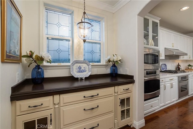 114 Via Monte Picayo, San Clemente, CA 92673 - kitchen with stainless steel appliances, under cabinet range hood, dark countertops, glass insert cabinets, and a chandelier