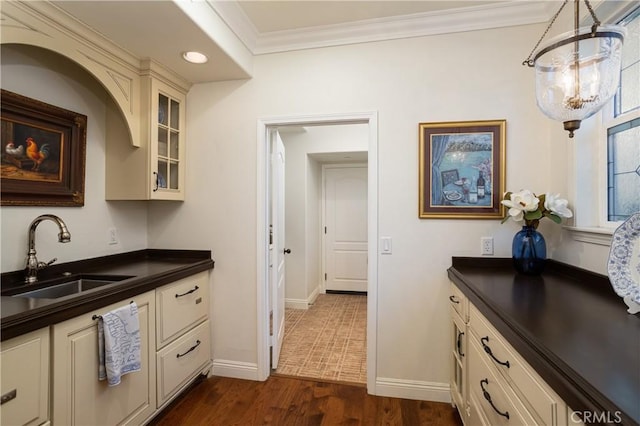 114 Via Monte Picayo, San Clemente, CA 92673 - kitchen featuring a sink, dark countertops, glass insert cabinets, ornamental molding, and dark wood-style floors