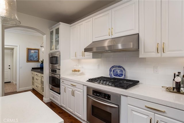 114 Via Monte Picayo, San Clemente, CA 92673 - kitchen featuring under cabinet range hood, appliances with stainless steel finishes, arched walkways, tasteful backsplash, and white cabinets