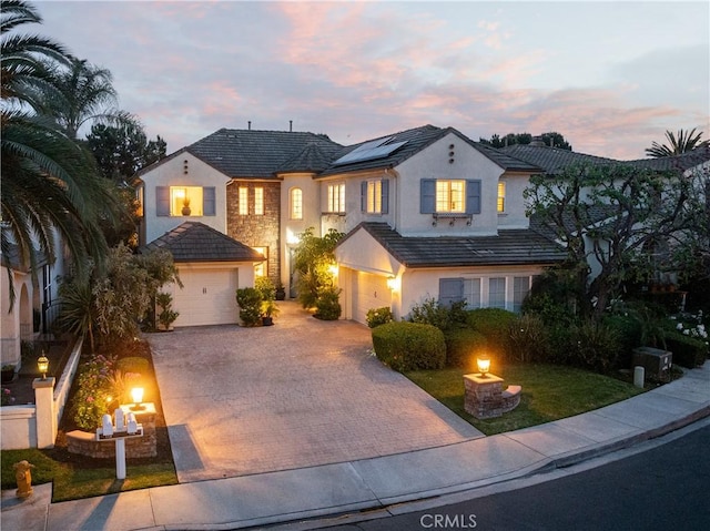 114 Via Monte Picayo, San Clemente, CA 92673 - traditional-style home with decorative driveway, stucco siding, roof mounted solar panels, an attached garage, and stone siding