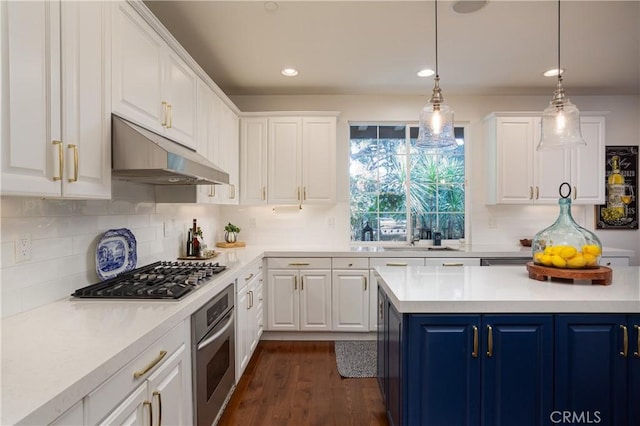114 Via Monte Picayo, San Clemente, CA 92673 - kitchen with stainless steel appliances, under cabinet range hood, blue cabinets, white cabinetry, and light countertops