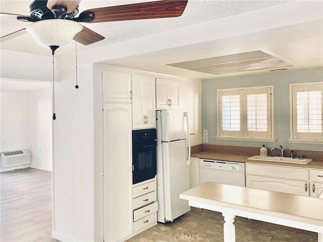897 Ronda Sevilla C, Laguna Woods, CA 92637 - kitchen with white appliances, white cabinetry, ceiling fan, and a wall mounted air conditioner