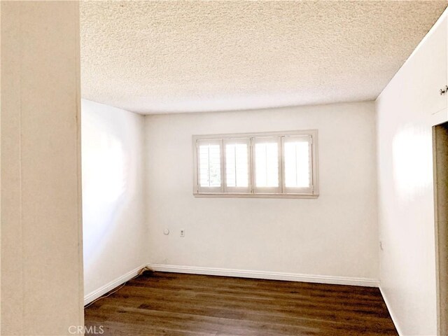 897 Ronda Sevilla C, Laguna Woods, CA 92637 - empty room featuring a textured ceiling and dark wood finished floors