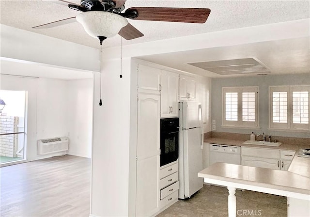897 Ronda Sevilla C, Laguna Woods, CA 92637 - kitchen featuring white appliances, white cabinetry, a wall mounted air conditioner, a ceiling fan, and a textured ceiling