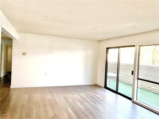 897 Ronda Sevilla C, Laguna Woods, CA 92637 - empty room with wood finished floors and a textured ceiling