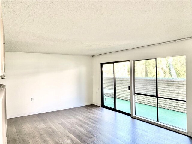 897 Ronda Sevilla C, Laguna Woods, CA 92637 - unfurnished room featuring a textured ceiling and wood finished floors