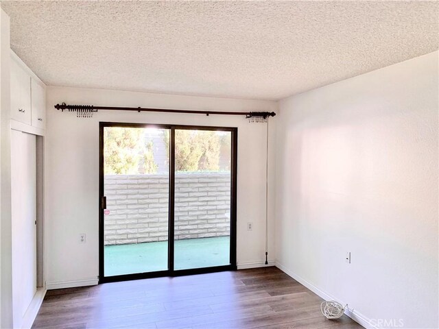 897 Ronda Sevilla C, Laguna Woods, CA 92637 - empty room featuring wood finished floors and a textured ceiling