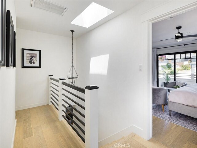 618 W Elm Ave, El Segundo, CA 90245 - hall with a skylight, light wood-style floors, baseboards, and an upstairs landing