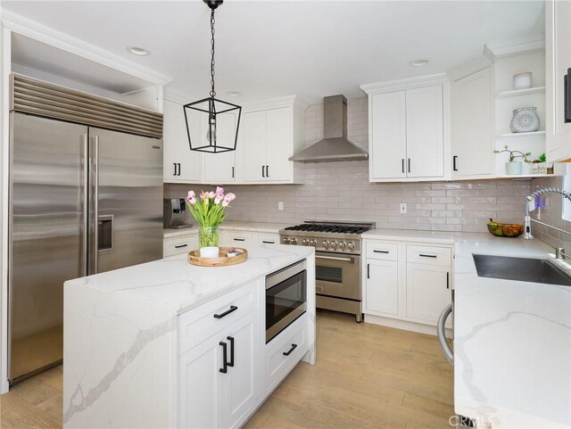618 W Elm Ave, El Segundo, CA 90245 - kitchen with built in appliances, wall chimney range hood, open shelves, a sink, and decorative light fixtures