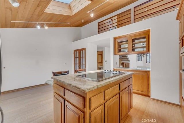 1110 Esplanade Unit 6, Redondo Beach, CA 90277 - kitchen with black electric stovetop, a skylight, a kitchen island, wooden ceiling, and rail lighting