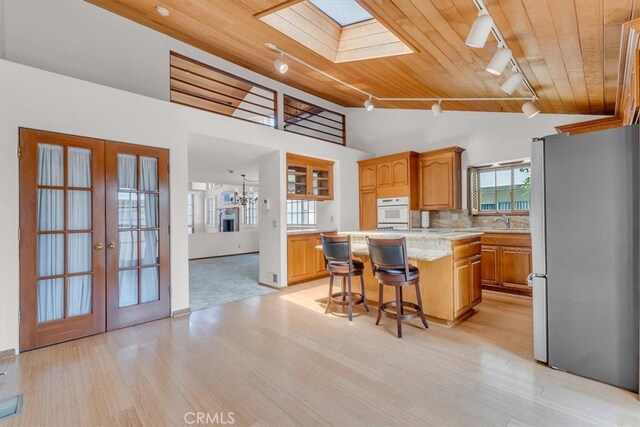 1110 Esplanade Unit 6, Redondo Beach, CA 90277 - kitchen with freestanding refrigerator, rail lighting, wood ceiling, oven, and french doors