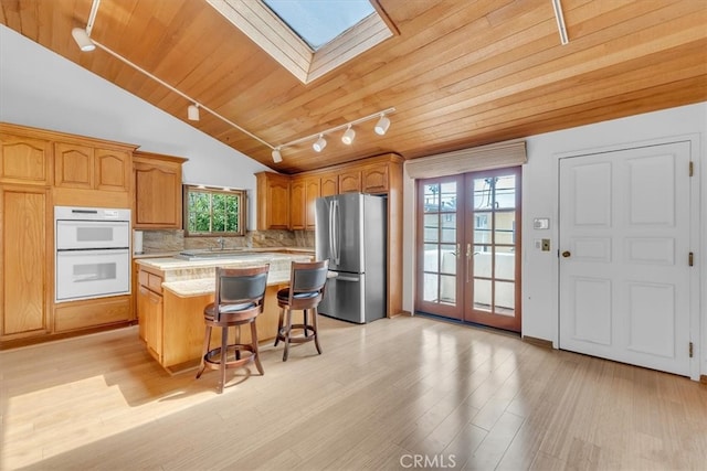 1110 Esplanade Unit 6, Redondo Beach, CA 90277 - kitchen featuring freestanding refrigerator, rail lighting, a skylight, light countertops, and white double oven