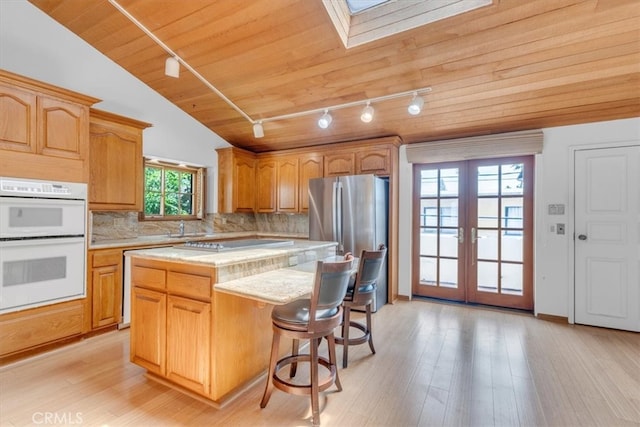 1110 Esplanade Unit 6, Redondo Beach, CA 90277 - kitchen with rail lighting, white double oven, light countertops, french doors, and a center island