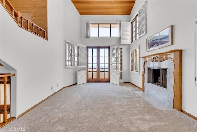1110 Esplanade Unit 6, Redondo Beach, CA 90277 - unfurnished living room with french doors, carpet floors, baseboards, a fireplace, and a towering ceiling