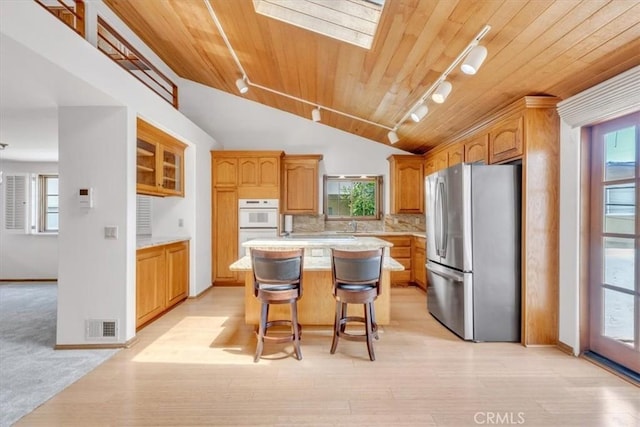 1110 Esplanade Unit 6, Redondo Beach, CA 90277 - kitchen featuring freestanding refrigerator, track lighting, wood ceiling, light countertops, and a center island