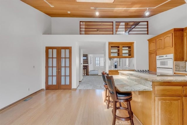 1110 Esplanade Unit 6, Redondo Beach, CA 90277 - kitchen with rail lighting, wood ceiling, light wood-style flooring, double oven, and french doors
