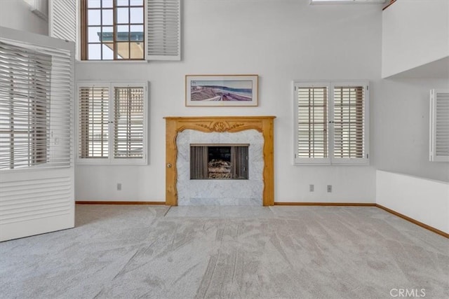 1110 Esplanade Unit 6, Redondo Beach, CA 90277 - unfurnished living room featuring a towering ceiling, carpet flooring, a high end fireplace, baseboards, and healthy amount of natural light
