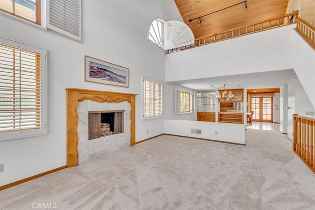 1110 Esplanade Unit 6, Redondo Beach, CA 90277 - unfurnished living room featuring a towering ceiling, wooden ceiling, a premium fireplace, carpet, and baseboards