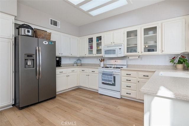 43340 Corte Barbaste, Temecula, CA 92592 - kitchen featuring white appliances, a sink, light wood-style flooring, light countertops, and white cabinetry