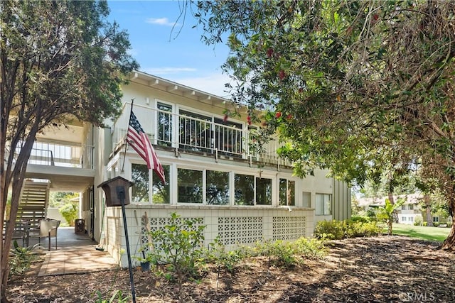 124 Via Estrada Unit O, Laguna Woods, CA 92637 - rear view of house featuring stairs, a balcony, and a patio