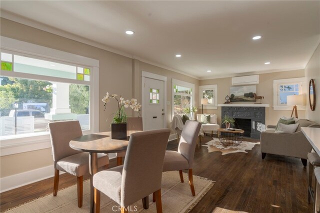 1322 N June St, Los Angeles, CA 90028 - dining area featuring a wall mounted AC, healthy amount of natural light, a fireplace, wood finished floors, and recessed lighting