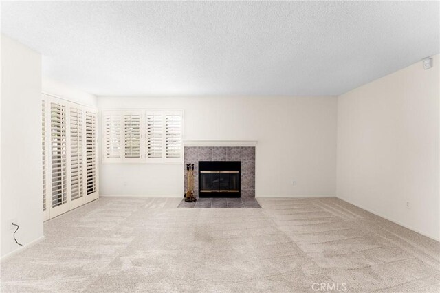 8313 Vineyard Ave # 6, Rancho Cucamonga, CA 91730 - unfurnished living room with carpet floors, a textured ceiling, and a tiled fireplace